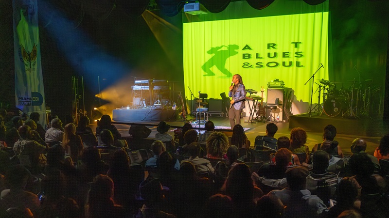 Singer on stage accompanied by piano.